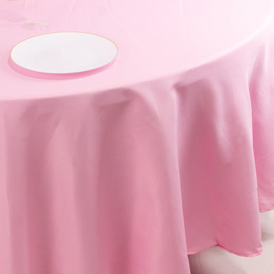 Pink tablecloth draped elegantly with a white plate on a table.