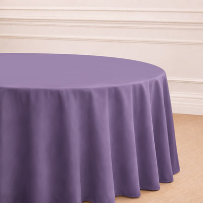 Purple round tablecloth draped over a table in a styled setting.