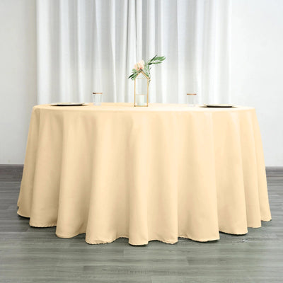 Beige round tablecloth draped over a table with floral centerpiece