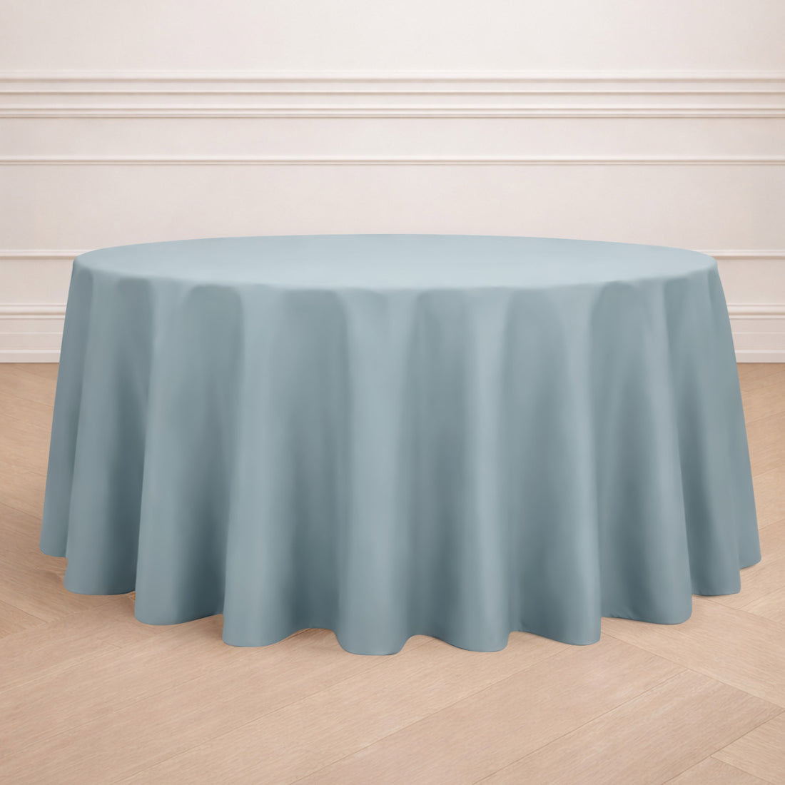 Round blue tablecloth draped over a table in a stylish setting.