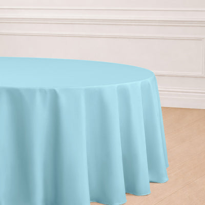 Round turquoise tablecloth draped over a table in a bright setting.