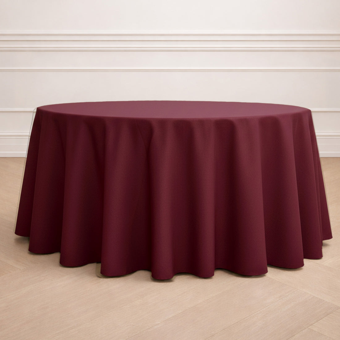 Round burgundy tablecloth on a wooden floor