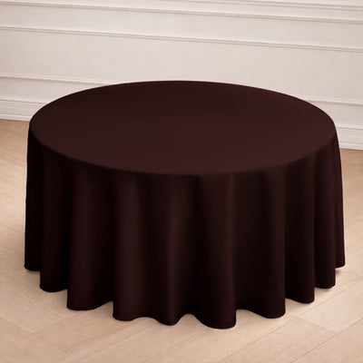Round burgundy tablecloth on a wooden floor backdrop.