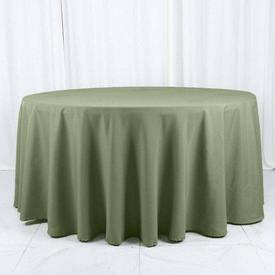Round olive green tablecloth on a white backdrop