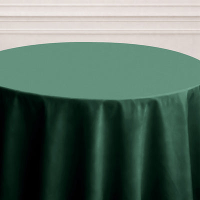 Green round tablecloth on a white table against a light background.