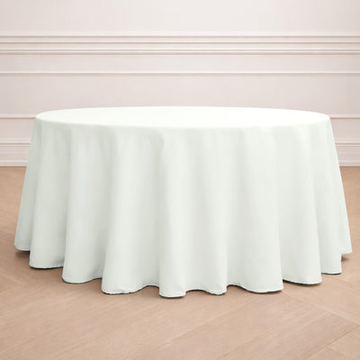 Round white tablecloth on a wooden floor backdrop.
