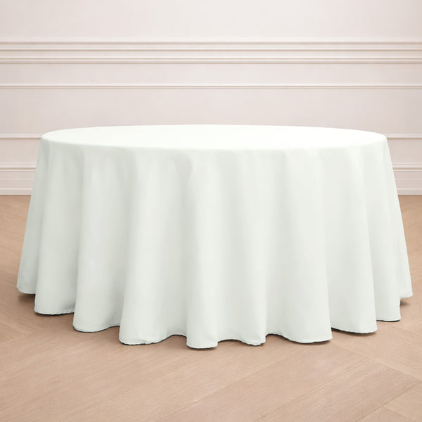 Round white tablecloth on a wooden floor backdrop.