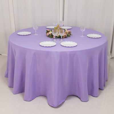 Round purple tablecloth draped over a table set for an event.