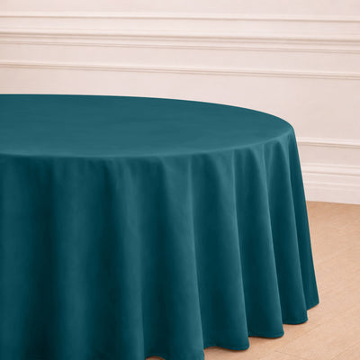 Teal round tablecloth draped elegantly on a table in a staged setting.