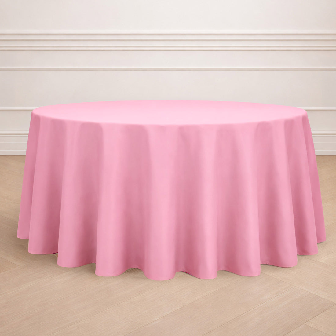 Round pink tablecloth draped elegantly over a circular table.
