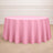 Round pink tablecloth draped elegantly over a circular table.