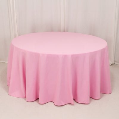 Round pink tablecloth on a plain backdrop.