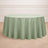 Round sage green tablecloth on a wooden floor.