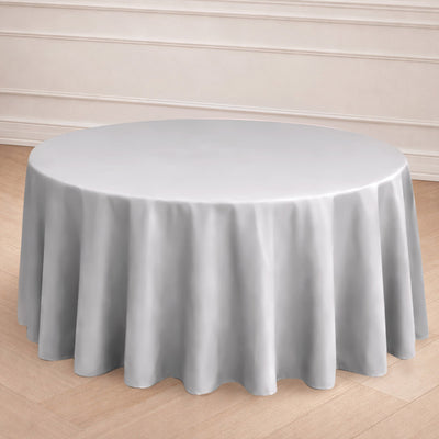 Round grey tablecloth on a wooden floor.
