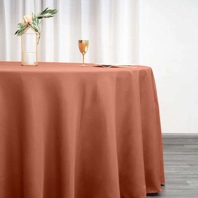 Elegant rust tablecloth draped on a table with decorative items.