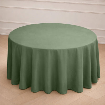 Round green tablecloth on a wooden floor.
