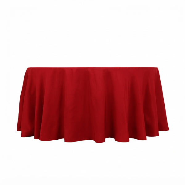 Red round tablecloth draped over a table on white background