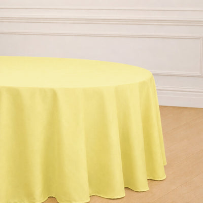 Yellow round tablecloth on a wooden table in a bright room.