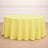 Round yellow tablecloth on a wooden floor.