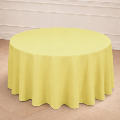 Round yellow tablecloth on a wooden floor backdrop.