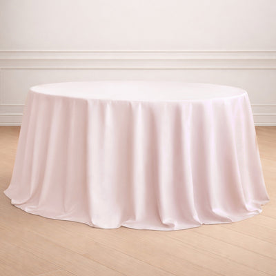 Round pink tablecloth draping elegantly over a table on a neutral background.