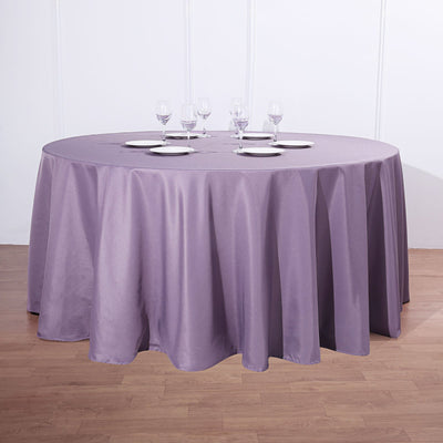 Round lavender tablecloth draped over a circular table with glassware set.