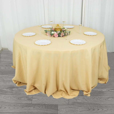 Round table set with a beige tablecloth and decorative plates.