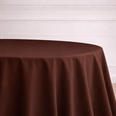 Brown tablecloth draped on a round table in a minimalistic setting.