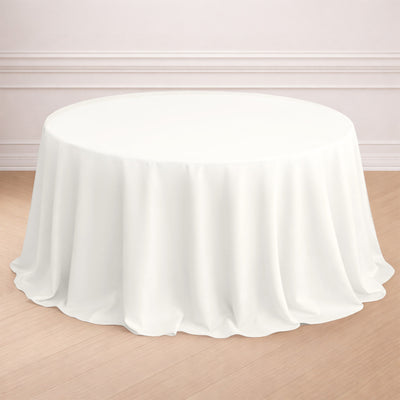 Round white tablecloth draped over a table in a styled setting.