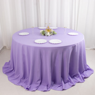 Round purple tablecloth draped elegantly over a round table with decorative plates.
