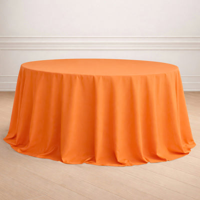 Round orange tablecloth draped elegantly on a circular table.