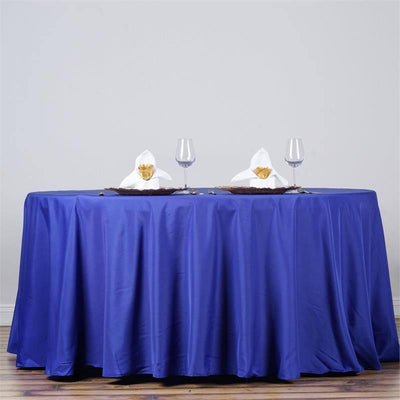 Blue tablecloth with elegant napkin and glass setup on a dining table.