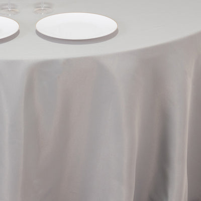 Elegant gray tablecloth draped over a table with plates and glasses.
