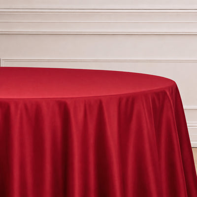 Red round table with draped cloth against a white paneled wall