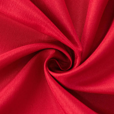 Close-up of red satin fabric swirls with soft folds and glossy texture#whtbkgd