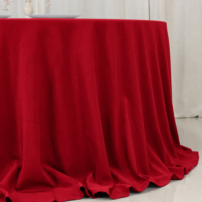 Red tablecloth draped over round table in elegant dining room