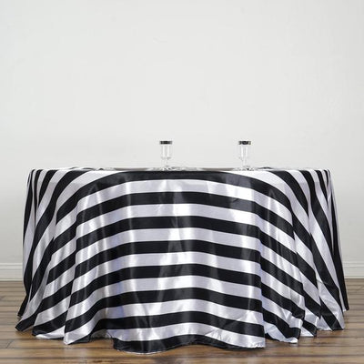 Black and white striped tablecloth draped over a round table.