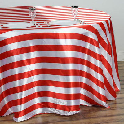 Red and white striped tablecloth draping over a round table.