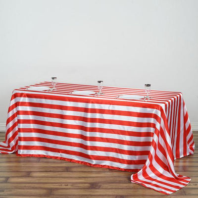 Red and white striped tablecloth draped over a table with glasses on top.