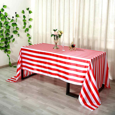 Red and white striped tablecloth draped on a table in a decorated setting.
