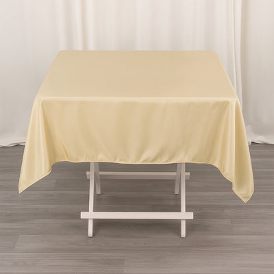 Beige tablecloth draped over a white table in a studio setting.