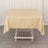 Beige tablecloth draped over a white table in a studio setting.