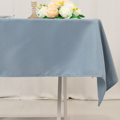 Blue tablecloth draped over a table with decorative flowers on top.