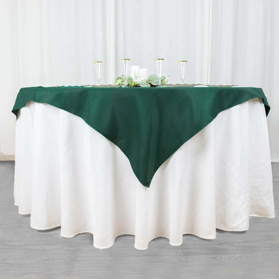 Green tablecloth draped over a round white table with decorative elements