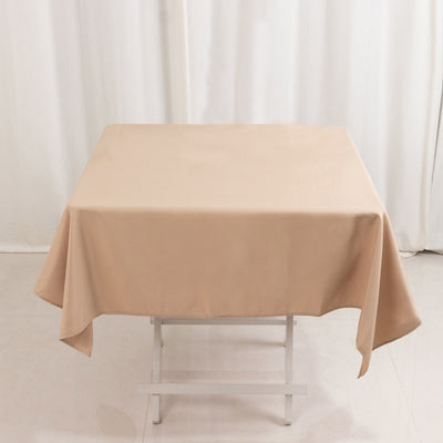 Beige tablecloth draped over a folding table in a studio setting.