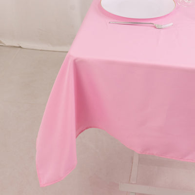 Pink tablecloth draped over a table with a plate and fork.