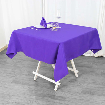 Purple tablecloth on a dining table with elegant setting.