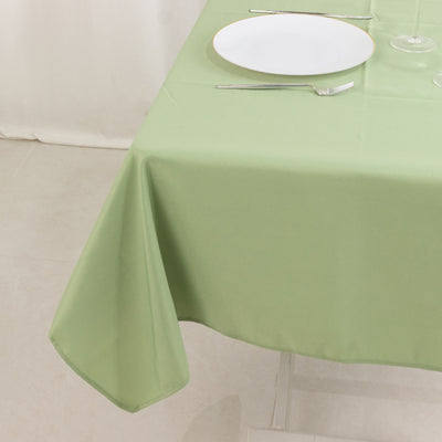 Green tablecloth draped elegantly on a table with dinnerware.