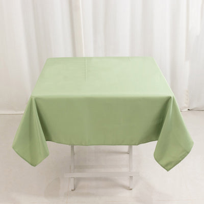 Green tablecloth on a white table in a bright setting.