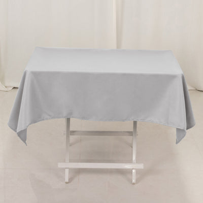 Gray tablecloth draped over a white folding table